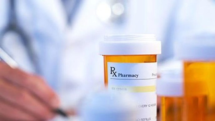 Photo of a pill bottle and a doctor writing notes