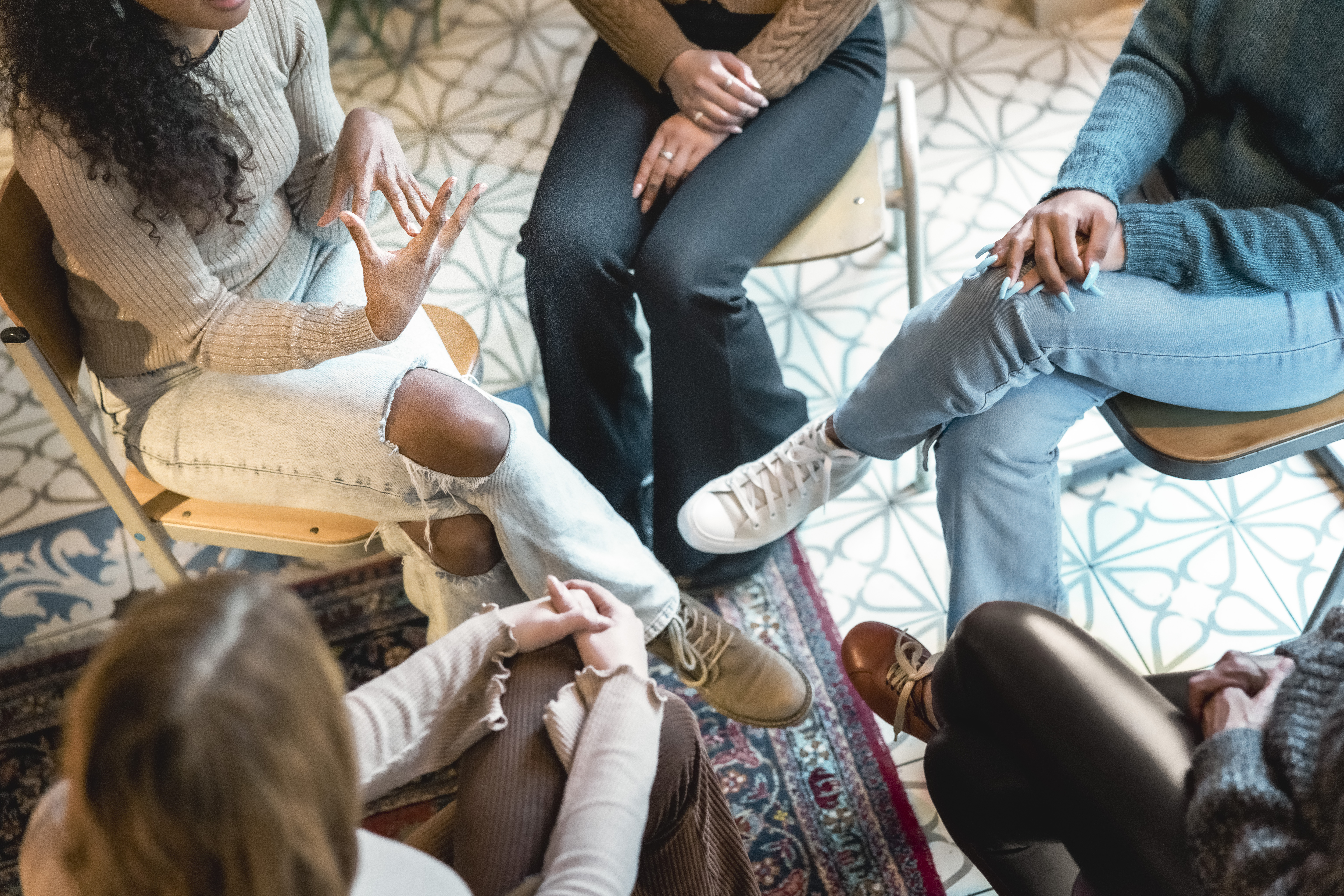 Women sitting in a circle having a conversation during a mental health group therapy session